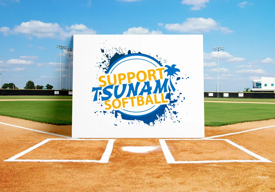 Fundraiser board on a softball field reading "Support Tsunami Softball", the wordmark set in a blue paint splash with a palm tree